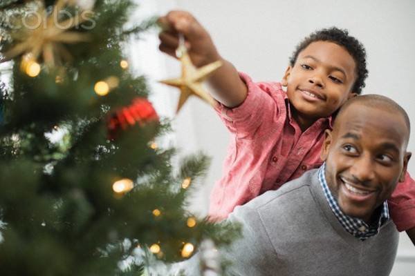 Father and son ( 6-7 years) decorating Christmas tree --- Image by © Hiya Images/Corbis