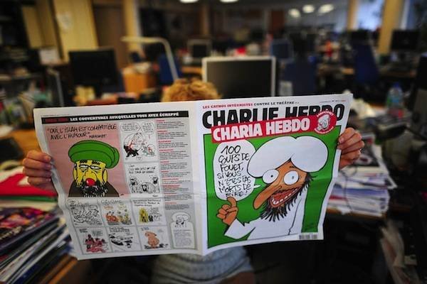 A person reads on November 1, 2011 in Paris an issue of Satirical French magazine Charlie Hebdo to be published on November 2, 2011, whose cover features prophet Mohammed. "In order fittingly to celebrate the Islamist Ennahda's win in Tunisia and the NTC (National Transitional Council) president's promise that sharia would be the main source of law in Libya, Charlie Hebdo asked Mohammed to be guest editor," said a statement. AFP PHOTO MARTIN BUREAU