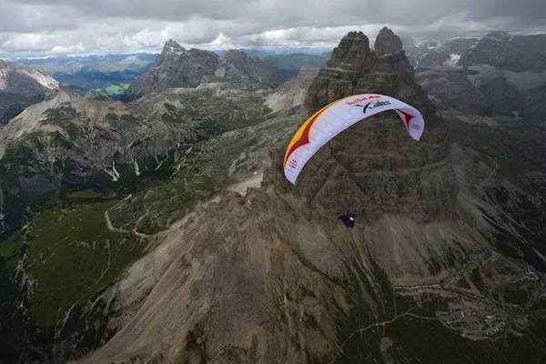 Athlete flying in front of the turnpoint Tre Cime at the Red Bull X-Alps in Italy on the 21th of july 2011